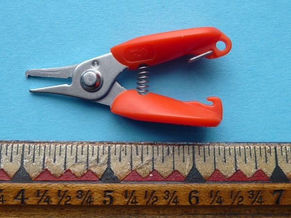 Daiwa split ring pliers next to a ruler. They're about 2 1/2 inches long.