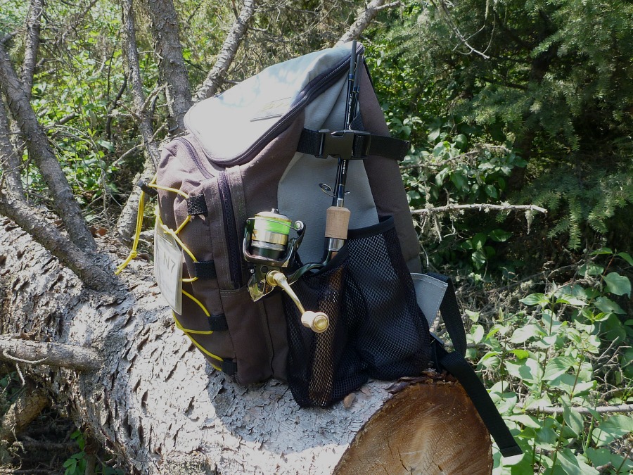 Backpack on a log with 4-piece rod in the rod holder.